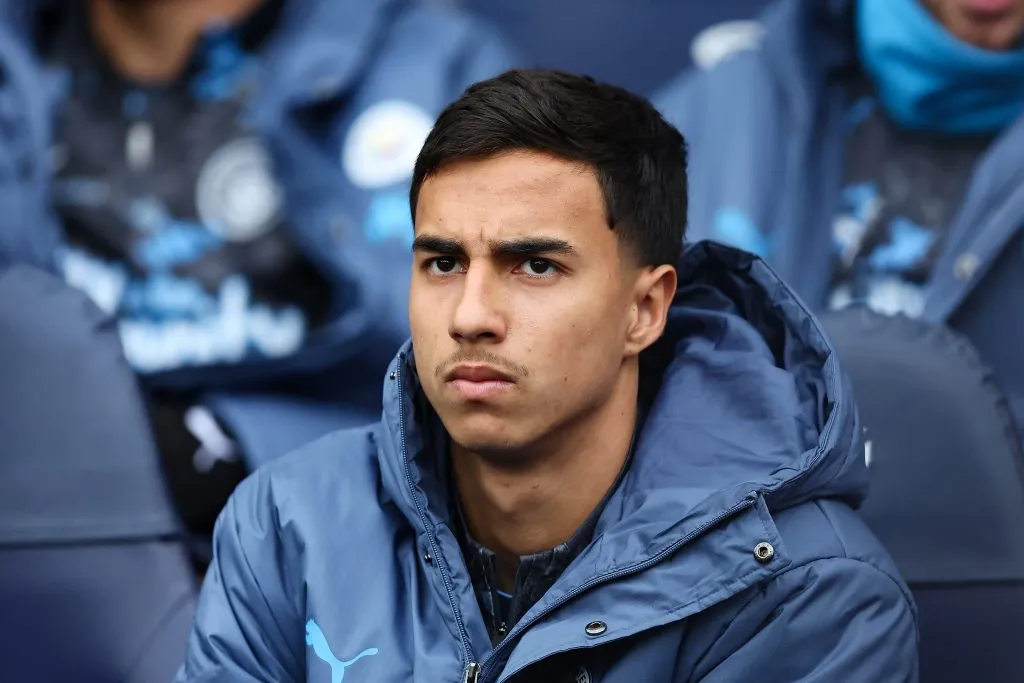 MANCHESTER, ENGLAND – MARCH 15: Vitor Reis of Manchester City looks on from the substitutes bench during the Premier League match between Manchester City FC and Brighton & Hove Albion FC at Etihad Stadium on March 15, 2025 in Manchester, England. (Photo by Matt McNulty/Getty Images)