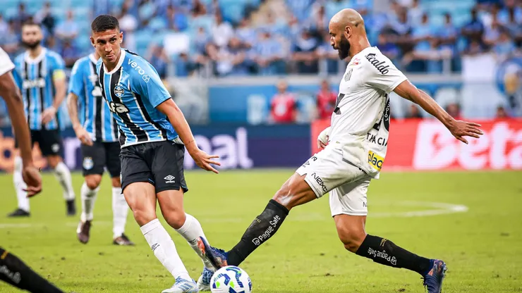 Thaciano, meia-atacante do Santos disputa lance com Miguel Monsalve jogador do Gremio durante partida contra na Arena do Gremio pelo campeonato Brasileiro A 2025