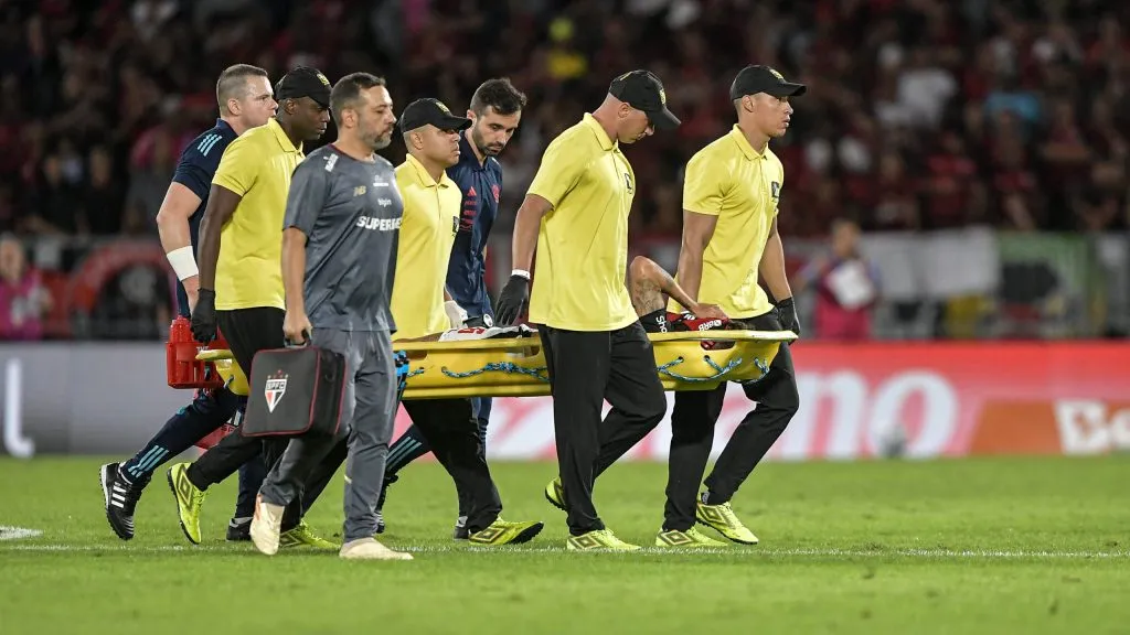 Ayrton Lucas deixando o campo de maca. Foto: Thiago Ribeiro/AGIF