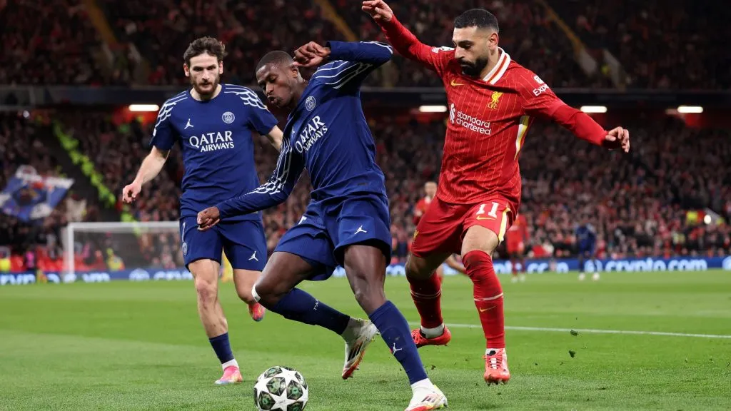 LIVERPOOL, ENGLAND – MARCH 11: Nuno Mendes of Paris Saint-Germain controls the ball under pressure from Mohamed Salah of Liverpool during the UEFA Champions League 2024/25 Round of 16 Second Leg match between Liverpool FC and Paris Saint-Germain at Anfield on March 11, 2025 in Liverpool, England. (Photo by Julian Finney/Getty Images)