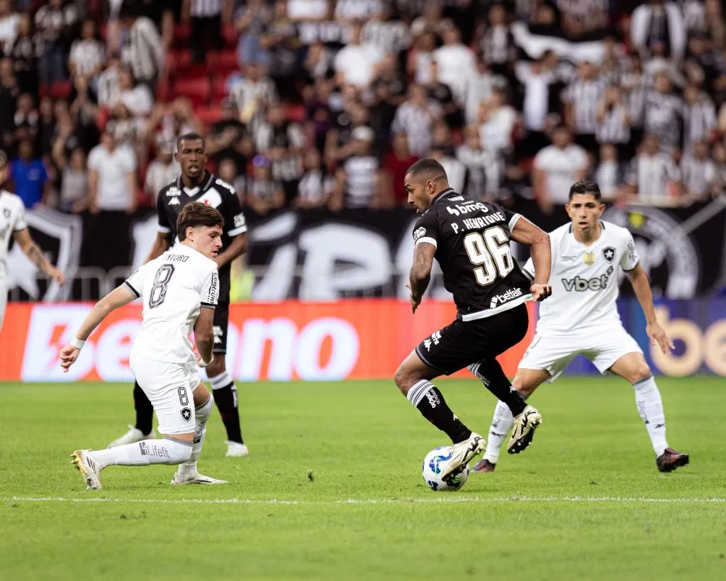 Jogador do Vasco disputa lance com jogador do Botafogo durante partida no estadio Mane Garrincha pelo campeonato Brasileiro A 2025. Foto: Mateus Dutra/AGIF