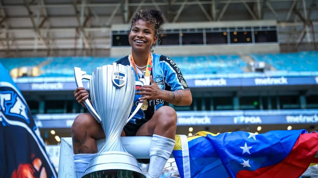 Jogadora do Grêmio com taça do Campeonato Gaúcho Feminino