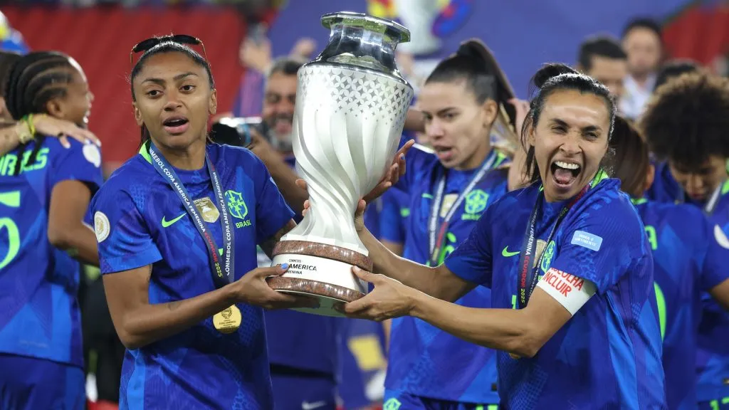 QUITO, ECUADOR – AUGUST 2: Marta Vieira and Kerolin Israel of Brazil hold the trophy after the CONMEBOL Copa America Femenina 2025 Final match between Colombia and Brazil at Rodrigo Paz Delgado Stadium on August 2, 2025 in Quito, Ecuador.  (Photo by Franklin Jacome/Getty Images)