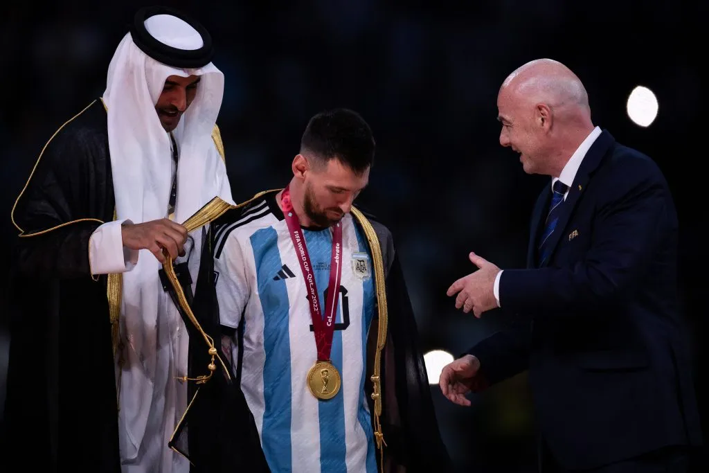 Catar – Doha – 18/12/2022 – COPA DO MUNDO 2022 FINAL, ARGENTINA X FRANCA – Ao lado do presidente da Fifa Gianni Infantino, o emir do Qatar Tamim bin Hamad bin Khalifa al-Thani veste com uma roupa tipica do pais o jogador Messi durante cerimonia de premiacao apos vitoria na partida contra o Franca no estadio Lusail pela decisao do campeonato Copa do Mundo 2022. Foto: Pedro Martins/AGIF