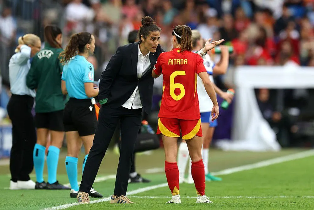 Montse Tomé conversa com Aitana Bonmatí durante a final da Eurocopa Feminina 2025. Foto: Alexander Hassenstein