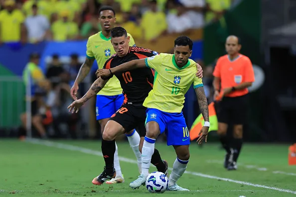 Rodrygo, da Seleção controla a bola sob pressão de James Rodriguez, da Colômbia, durante o jogo de qualificação para a Copa do Mundo no Mane Garrincha (2025). Foto: Buda Mendes/Getty Images
