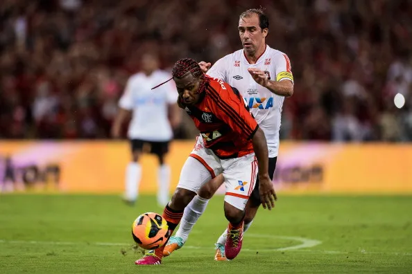 Paulo Baier, do Atletico Paranaense disputa lance com Amaral do Flamengo e o Atlético Paranaense no Maracanã Stadium, na temporada 2013. Foto: Buda Mendes/Getty Images
