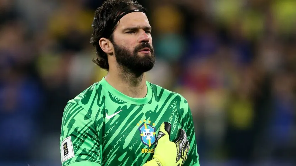 Alisson cantando o hino nacional antes de Brasil x Paraguai – Foto: Marlon Costa/AGIF