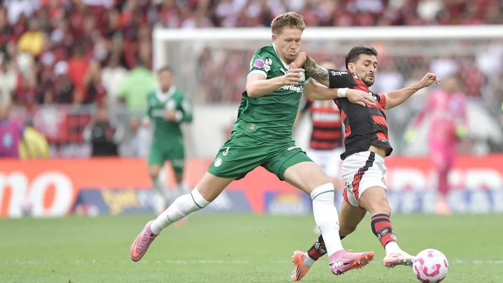 Arrascaeta jogador do Flamengo disputa lance com Fuchs jogador do Palmeiras durante partida no estadio Maracana pelo campeonato Brasileiro A 2025. Foto: Thiago Ribeiro/AGIF