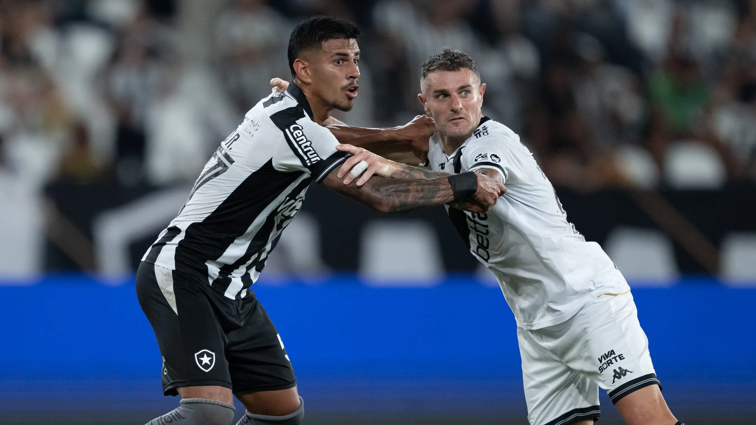 David Ricardo jogador do Botafogo disputa lance com Vegetti jogador do Vasco durante partida no estadio Engenhao pelo campeonato Brasileiro A 2025. Foto: Jorge Rodrigues/AGIF