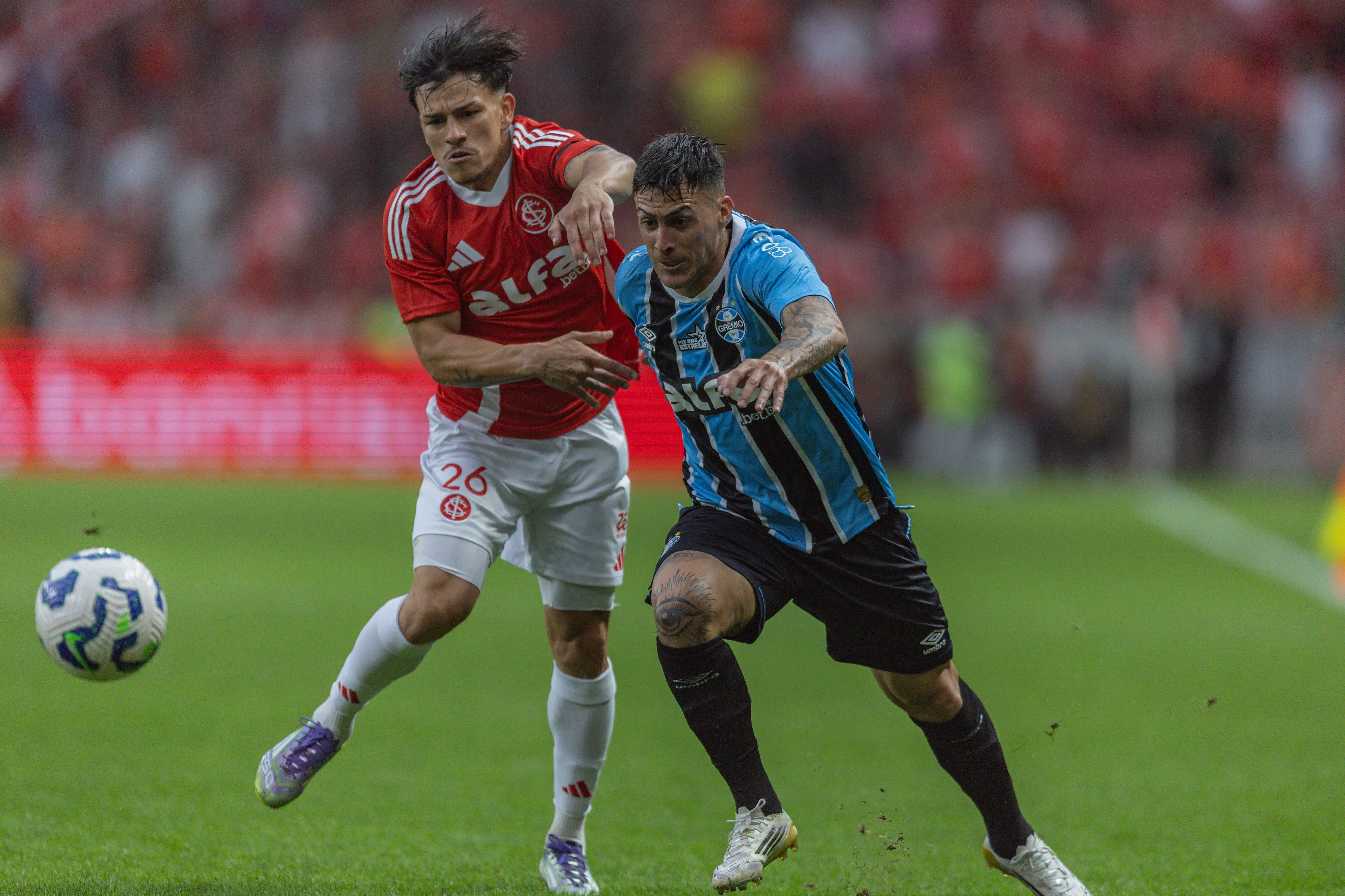 Alexandro Bernabei, jogador do Internacional, disputa lance com Cristian Pavon jogador do Gremio durante partida no estadio Beira-Rio pelo campeonato Brasileiro A 2025. Foto: Liamara Polli/AGIF