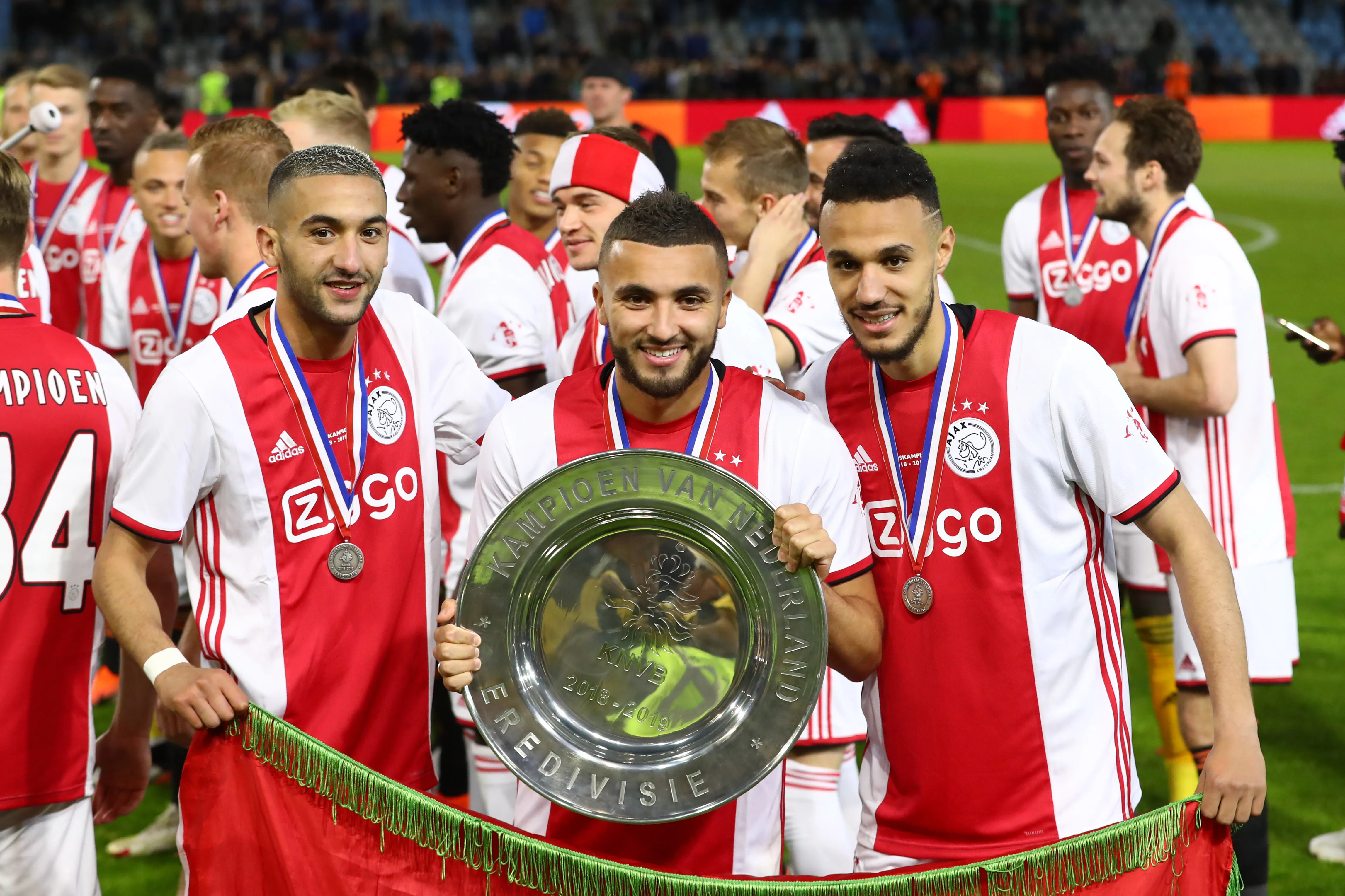 Hakim Ziyech of Ajax, Zakaria Labyad of Ajax and Noussair Mazraoui of Ajax celebrate with the trophy after winning the Eredivisie following the Eredivisie match between De Graafschap and Ajax at Stadion De Vijverberg on May 15, 2019 in Doetinchem, Netherlands. (Photo by Dean Mouhtaropoulos/Getty Images)