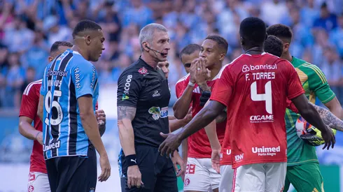 Jogadores do Gremio e do Internacional discutem com Anderson Daronco durante partida no estadio Arena do Gremio pelo campeonato Gaucho 2026. Foto: Maxi Franzoi/AGIF