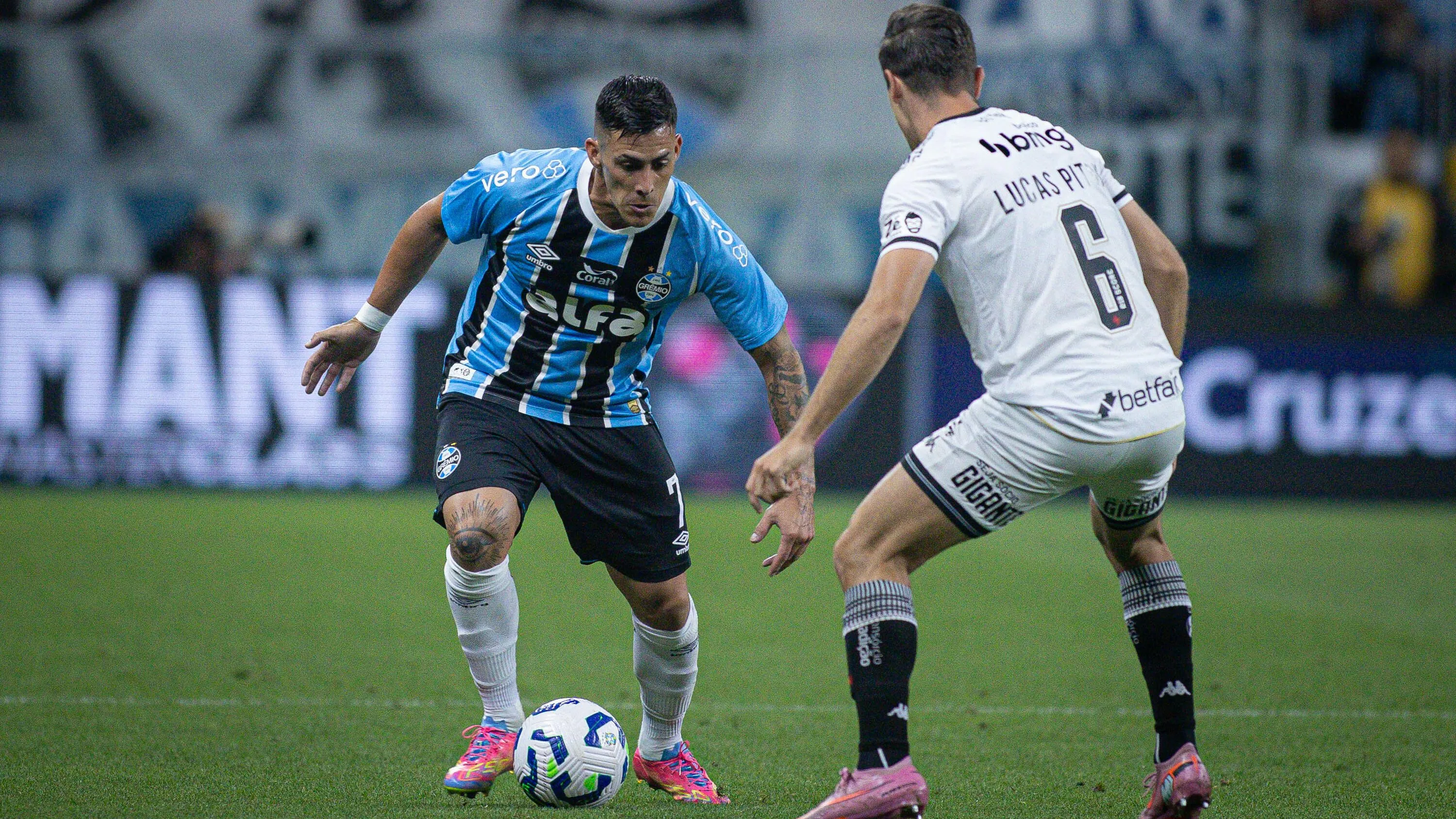 Cristian Pavon jogador do Gremio disputa lance com Lucas Piton jogador do Vasco durante partida no estadio Arena do Gremio pelo campeonato Brasileiro A 2025. Foto: Maxi Franzoi/AGIF