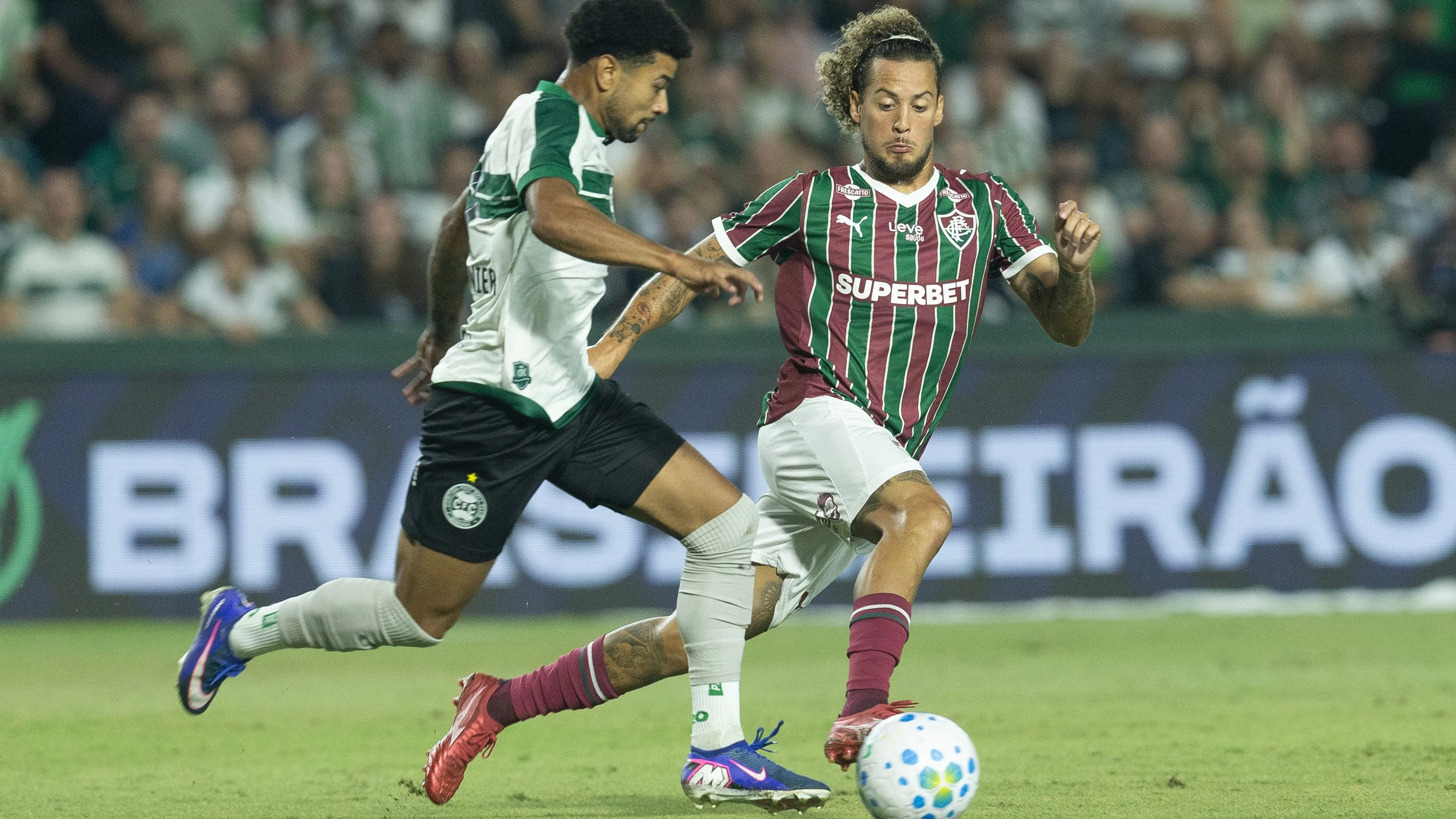 Lucas Ronier jogador do Coritiba disputa lance com Guga jogador do Fluminense durante partida no estadio Couto Pereira pelo campeonato Brasileiro A 2026. Foto: Hedeson Alves/AGIF