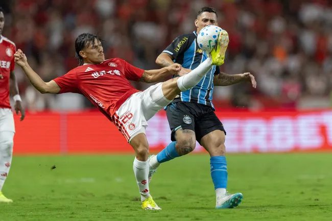 Bernabei jogador do Internacional disputa lance com Pavon jogador do Gremio durante partida no estadio Beira-Rio pelo campeonato Brasileiro A 2026. Foto: Liamara Polli/AGIF
