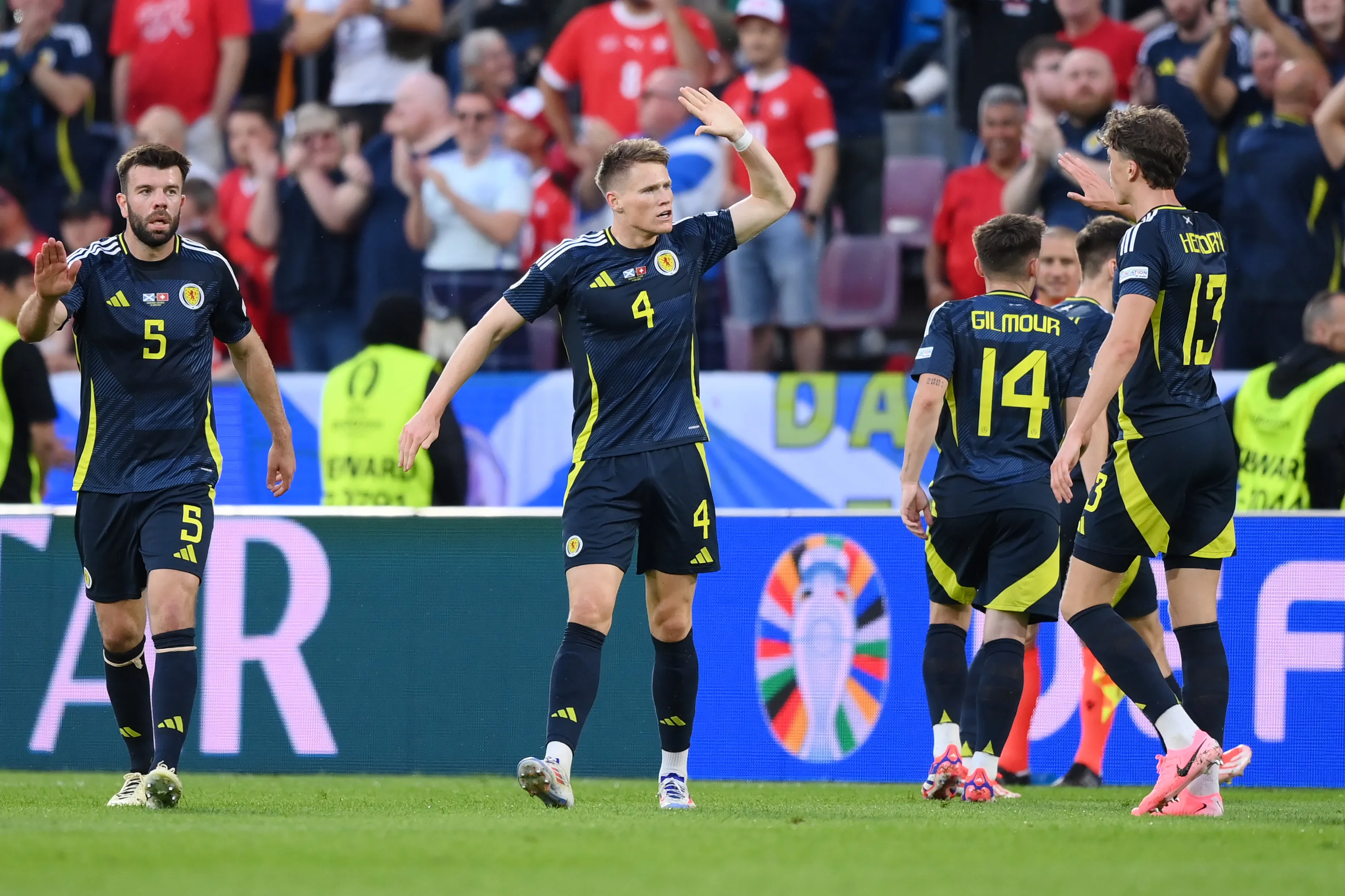 COLOGNE, GERMANY – JUNE 19: Scott McTominay of Scotland celebrates with teammates after Fabian Schaer of Switzerland (not pictured) deflects his shot, leading to an own goal and the first goal for Scotland, during the UEFA EURO 2024 group stage match between Scotland and Switzerland at Cologne Stadium on June 19, 2024 in Cologne, Germany. (Photo by Justin Setterfield/Getty Images)