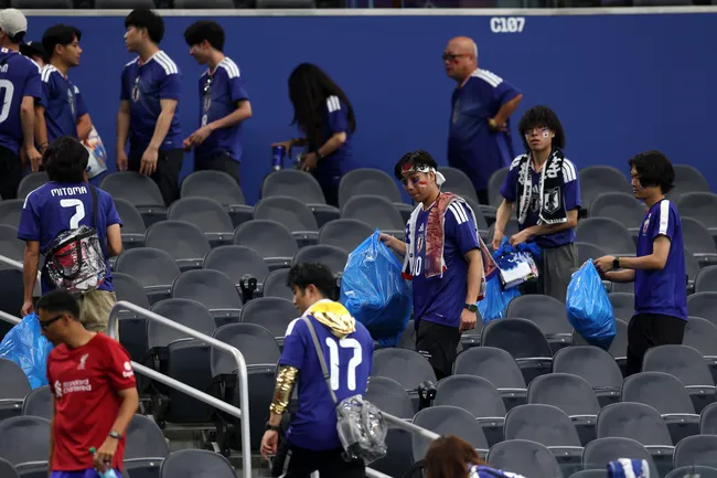 Torcedores japoneses limpam as arquibancadas após empate. Foto: Michael Steele/Getty Images.