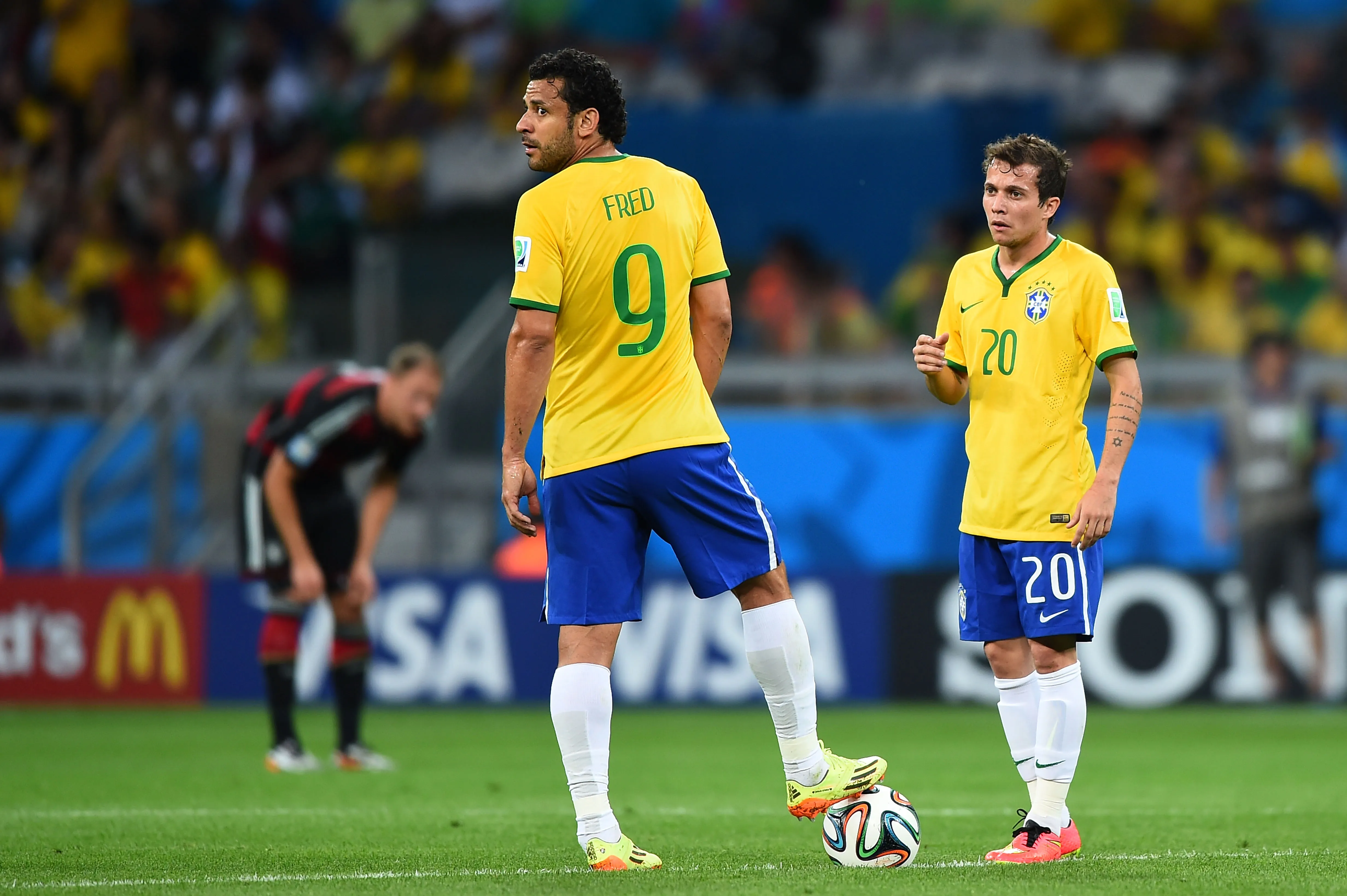 BELO HORIZONTE, BRAZIL – JULY 08:  Fred  and Bernard of Brazil prepare to kick off after allowing a goal during the 2014 FIFA World Cup Brazil Semi Final match between Brazil and Germany at Estadio Mineirao on July 8, 2014 in Belo Horizonte, Brazil.  (Photo by Laurence Griffiths/Getty Images)