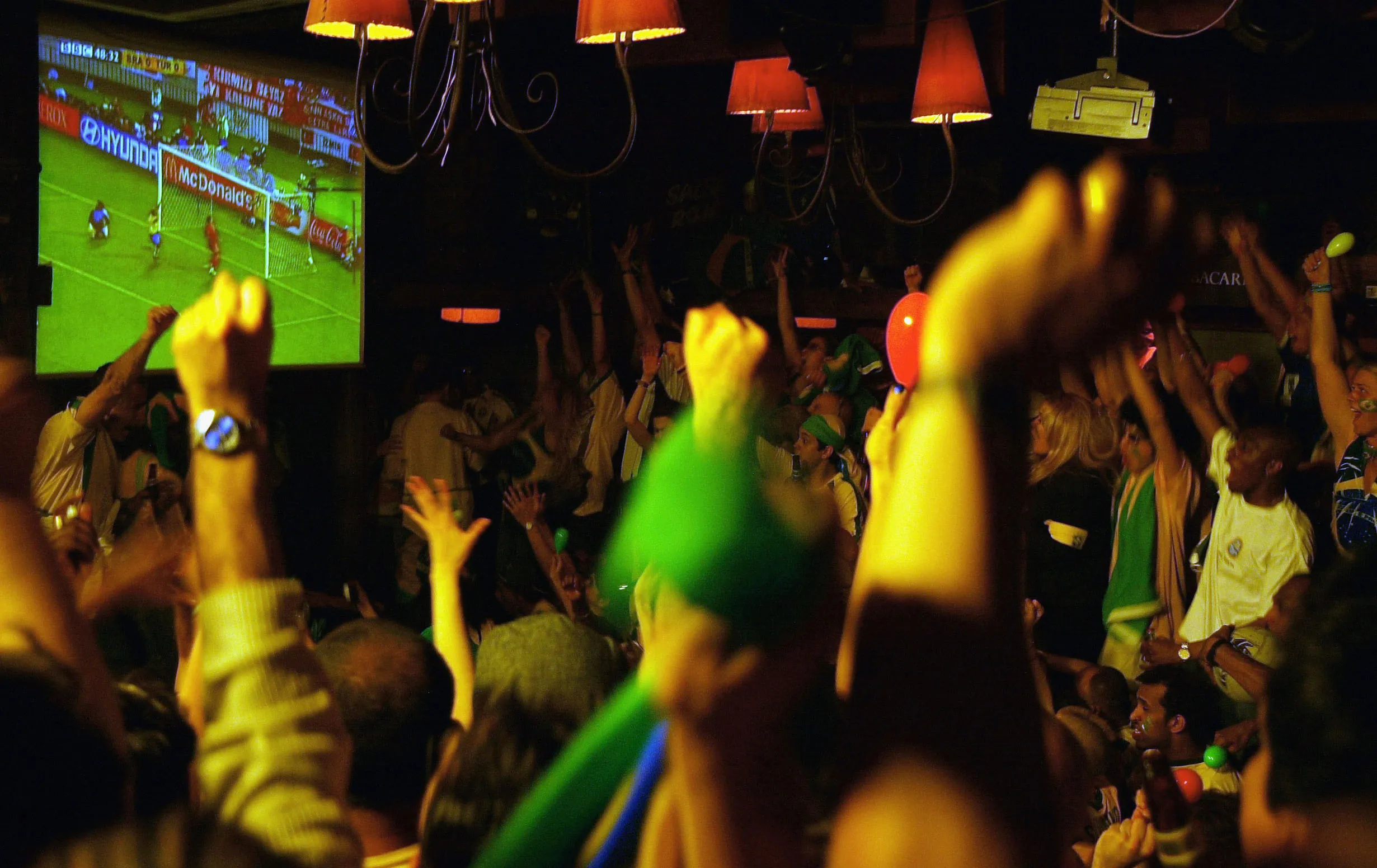LONDON – JUNE 26 :  Brazil fans watching the World Cup semi final between Brazil and Turkey, celebrate Ronaldo of Brazil scoring the winning goal, at Bart Salsa in London on June 26, 2002. (Photo by Christopher Lee / Getty Images)