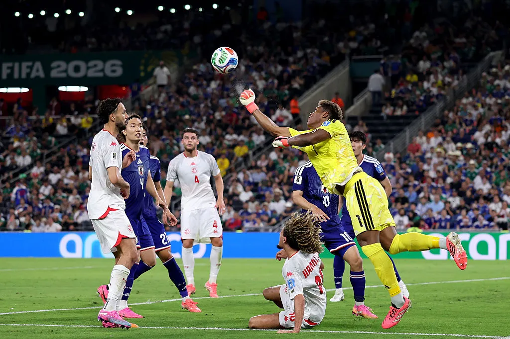 Zion Suzuki, camisa 1 do Japão, faz uma defesa contra Hannibal Mejbri, camisa 10 da Tunísia. (Photo by Luke Hales/Getty Images)
