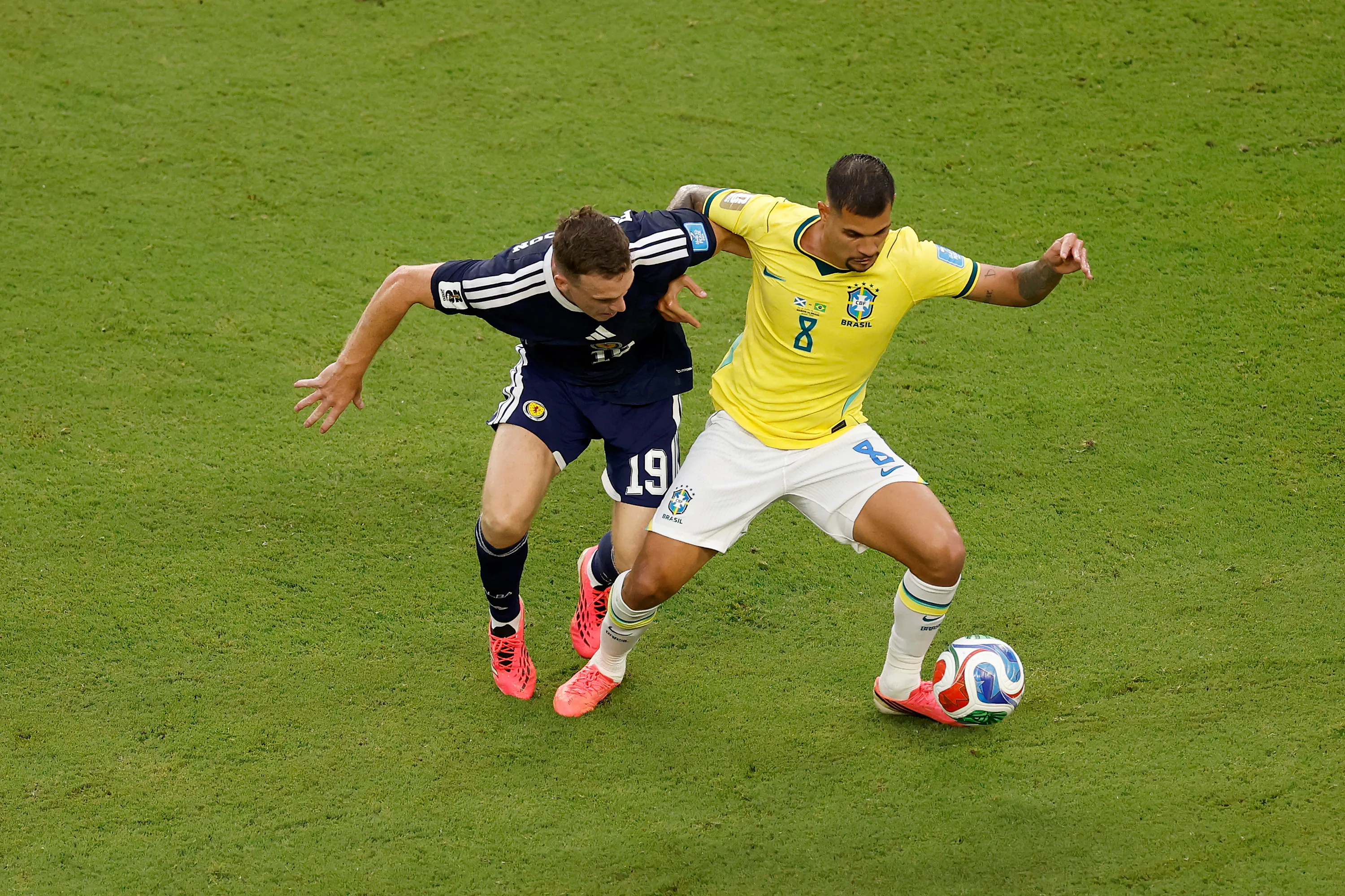 MIAMI GARDENS, FLORIDA – JUNE 24: Bruno Guimaraes #8 of Brazil is challenged by Lewis Ferguson #19 of Scotland during the FIFA World Cup 2026 Group C match between Scotland and Brazil at Miami Stadium on June 24, 2026 in Miami Gardens, Florida. (Photo by Michael Reaves/Getty Images)