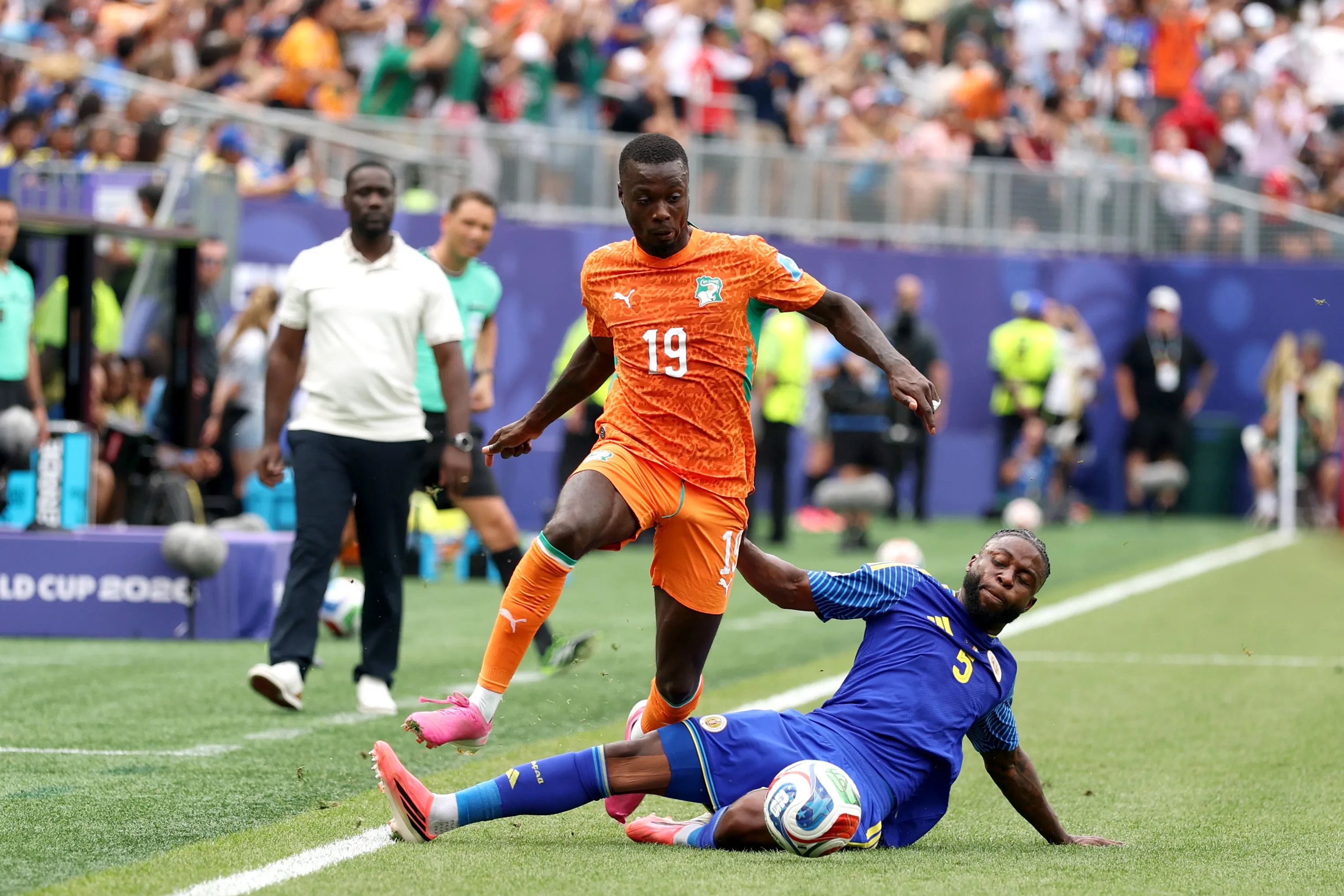 PHILADELPHIA, PENNSYLVANIA – JUNE 25: Nicolas Pepe #19 of Cote d’Ivoire is tackled by Sherel Floranus #5 of Curacao during the FIFA World Cup 2026 Group E match between Curacao and Cote D’Ivoire at Philadelphia Stadium on June 25, 2026 in Philadelphia, Pennsylvania. (Photo by Darrian Traynor/Getty Images)