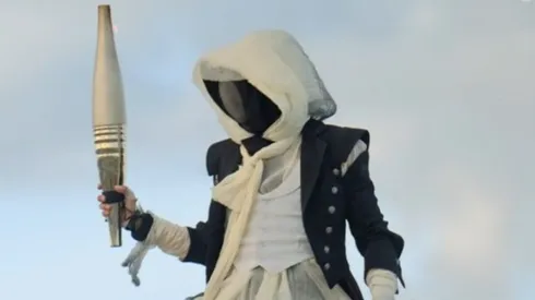 The masked man carrying the Olympic flame at the 2024 Games.