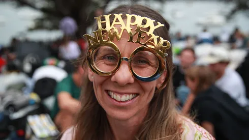 A woman poses for a photo wearing a Happy New Year headpiece at Mrs Macquarie's Chair during New Year's Eve celebrations in 2023.