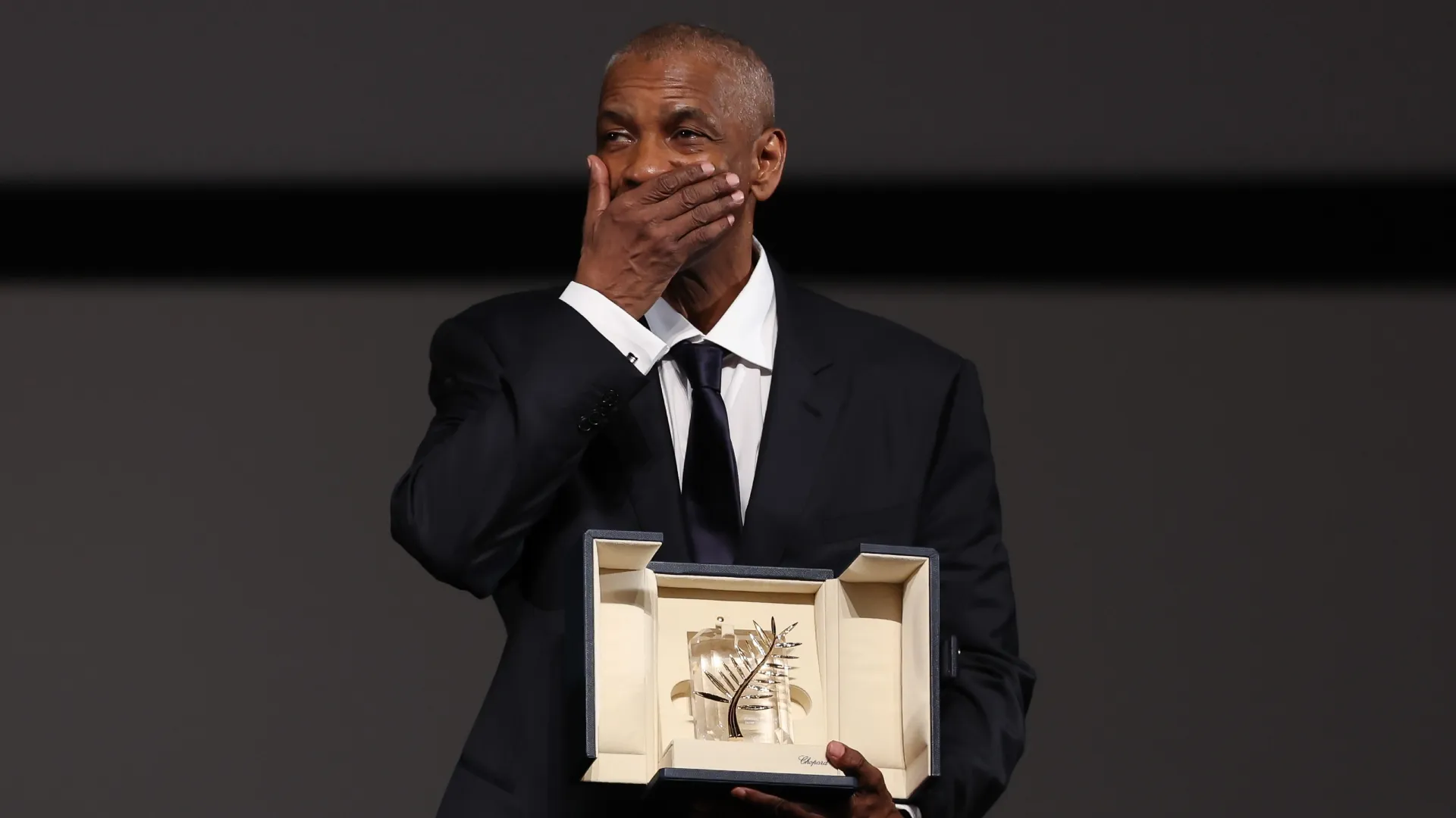 Denzel Washington poses after receiveing an honorary Palme d’Or following a screening for the “Highest 2 Lowest” at the 78th annual Cannes Film Festival at Palais des Festivals on May 19, 2025 in Cannes, France. (Photo by Sameer Al-Doumy/Pool/Getty Images)