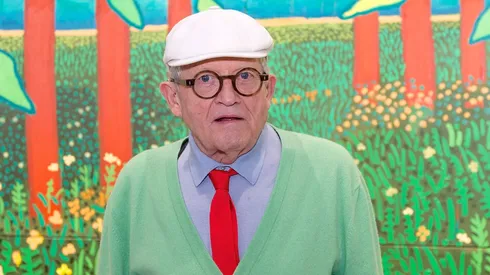 David Hockney poses in front of his painting "The Arrival Of Spring in Woldgate, East Yorkshire in 2011" which he offered to the museum at Centre Pompidou.