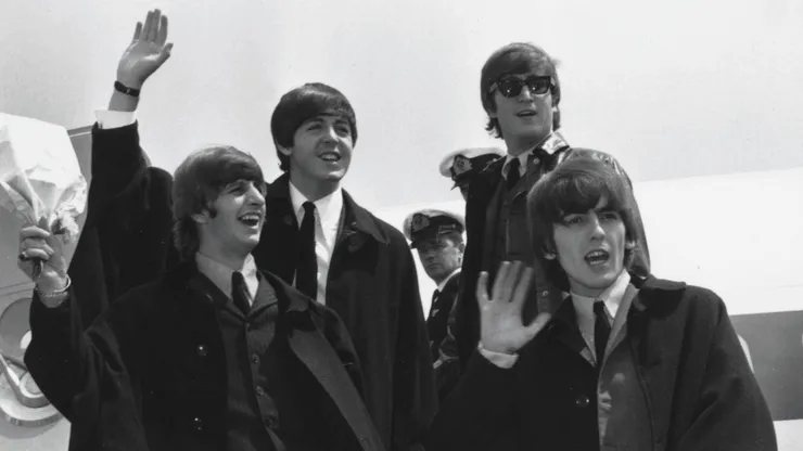 The Beatles (L to R) Ringo Starr, Paul McCartney, John Lennon and George Harrison wave to fans July 2, 1964 as they return to London from a tour of Australia.